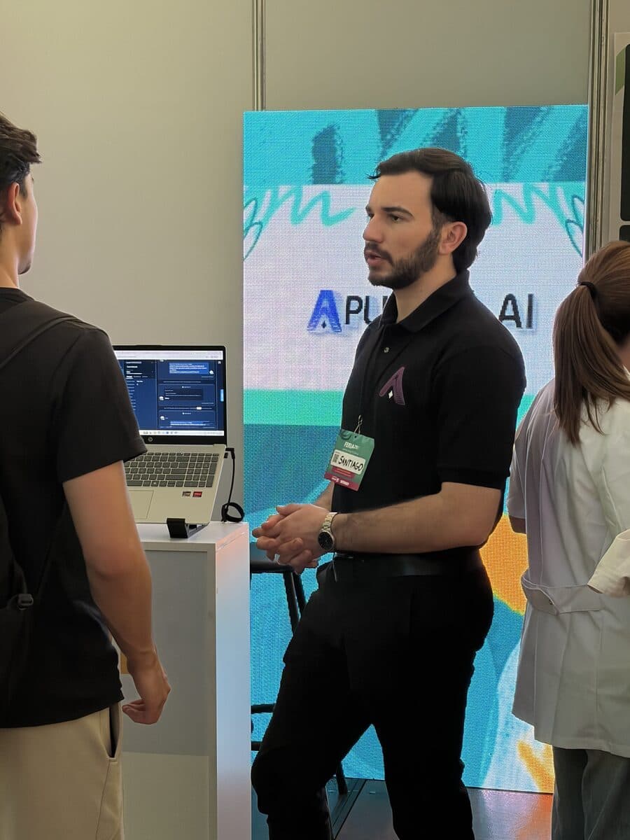 Team member in front of the Aplicada AI stand